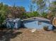 View of the backyard, detached garage, and lush surrounding trees at 501 15Th Ne Ct, Winter Haven, FL 33881