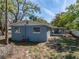 Backyard featuring a patio area, lush trees, and exterior view of the house at 501 15Th Ne Ct, Winter Haven, FL 33881