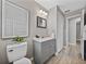 Bathroom with grey vanity, decorative mirror, and wood-look flooring at 501 15Th Ne Ct, Winter Haven, FL 33881