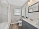 Bathroom featuring white marble tile in shower, grey vanity and wood-look floors at 501 15Th Ne Ct, Winter Haven, FL 33881