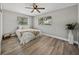 Bedroom with wood-look floors, ceiling fan and large windows at 501 15Th Ne Ct, Winter Haven, FL 33881