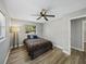 Cozy bedroom with ceiling fan, wood-look flooring, and window overlooking outside at 501 15Th Ne Ct, Winter Haven, FL 33881