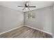 Bedroom with wood-look floors, ceiling fan, and window at 501 15Th Ne Ct, Winter Haven, FL 33881