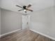 Bedroom with wood-look floors, ceiling fan and ensuite bathroom at 501 15Th Ne Ct, Winter Haven, FL 33881