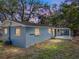 Exterior side view of a blue block home at dusk with a covered patio and adjacent yard at 501 15Th Ne Ct, Winter Haven, FL 33881