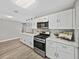 Modern kitchen with white cabinets, stainless steel appliances, and quartz countertops at 501 15Th Ne Ct, Winter Haven, FL 33881