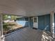 Tiled covered patio with a white door and small welcome mat at 501 15Th Ne Ct, Winter Haven, FL 33881