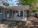 View of a tiled covered patio with a door to the home and access to the backyard at 501 15Th Ne Ct, Winter Haven, FL 33881