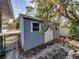 View of backyard shed with painted siding, paver patio, and gated access at 501 15Th Ne Ct, Winter Haven, FL 33881