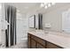 Well-lit bathroom featuring modern fixtures, a large vanity, and a shower-tub combo with stylish black and white striped curtain at 1423 Hamilton Way, Lake Alfred, FL 33850