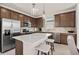 Modern kitchen with stainless steel appliances, a center island with seating, and beautiful wood cabinets at 1423 Hamilton Way, Lake Alfred, FL 33850
