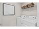 Functional laundry area equipped with white washer and dryer units and complemented by upper shelving at 1431 Hamilton Way, Lake Alfred, FL 33850