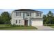 Inviting two-story home featuring light blue siding, a red front door, and attached two-car garage at 1177 Hour Glass Rd, Lakeland, FL 33801