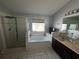 Bathroom features a glass enclosed shower, a soaking tub, double vanity sinks, and contemporary fixtures at 3035 Buckeye Pointe Dr, Winter Haven, FL 33881