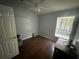 Cozy bedroom featuring a ceiling fan, dark hardwood floors, and natural light from a window at 3035 Buckeye Pointe Dr, Winter Haven, FL 33881