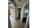 Hallway with tile flooring leading to a bright bathroom and outdoor access, creating a functional living space at 3035 Buckeye Pointe Dr, Winter Haven, FL 33881