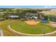 Aerial view featuring a baseball field, basketball court, and community buildings amidst lush landscaping at 6898 Sw 95Th Cir, Ocala, FL 34481