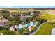 Aerial view of resort-style pool with lazy river, lounge areas, and cabanas surrounded by manicured landscape at 6898 Sw 95Th Cir, Ocala, FL 34481