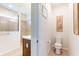 A modern tiled bathroom with a walk-in shower, toilet, sink, and natural light from the window at 6898 Sw 95Th Cir, Ocala, FL 34481