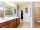 Bathroom featuring double sinks, vanity, a glass-enclosed shower, and a walk-in closet at 6898 Sw 95Th Cir, Ocala, FL 34481