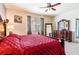 Spacious bedroom featuring a statement mirror, ceiling fan, and window providing natural light at 6898 Sw 95Th Cir, Ocala, FL 34481