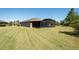 Rear exterior of home featuring a screened-in lanai and spacious backyard with verdant lawn at 6898 Sw 95Th Cir, Ocala, FL 34481