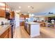 Modern kitchen with granite countertops, stainless steel appliances, an island, and an open view to the living area at 6898 Sw 95Th Cir, Ocala, FL 34481