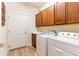 Bright laundry room with sink, washer, dryer, wood-look flooring, and ample cabinet space at 6898 Sw 95Th Cir, Ocala, FL 34481