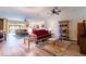 Bright open living room with wood floors, ceiling fans, and a view to the patio at 6898 Sw 95Th Cir, Ocala, FL 34481