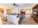 Spacious living room with wood-look flooring, ceiling fans, and seamless flow to the kitchen and dining areas at 6898 Sw 95Th Cir, Ocala, FL 34481