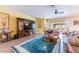 Bright living room with a decorative rug, entertainment center, and sliding glass doors leading to a screened patio at 6898 Sw 95Th Cir, Ocala, FL 34481