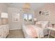 Charming bedroom with light pink accents, bright natural light, and comfy decorative pillows to match the artwork at 1687 Ruby Ln, Lake Alfred, FL 33850