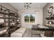 Comfortable home office with a large shelving unit, work desk and a bench seat illuminated by a stylish light fixture at 1687 Ruby Ln, Lake Alfred, FL 33850