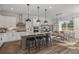 Bright kitchen features an island with barstool seating, pendant lighting, modern appliances and a dining area at 1687 Ruby Ln, Lake Alfred, FL 33850