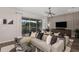 Inviting living room with neutral tones, sleek light fixture, and sliding glass doors opening to the outdoor patio at 1687 Ruby Ln, Lake Alfred, FL 33850