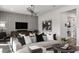 Stylish living room with gray textured accent wall, modern light fixture, and comfortable gray sectional sofa at 1687 Ruby Ln, Lake Alfred, FL 33850