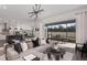 Open-concept living room with gray sofa, pendant lighting, kitchen access and sliding glass doors to an outdoor patio at 1687 Ruby Ln, Lake Alfred, FL 33850