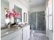 Elegant bathroom with double vanity, large mirrors, glass shower, and stylish gray tile at 2276 Red Sun St, Apopka, FL 32703