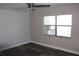 Cozy bedroom with wood-look floors, ceiling fan, natural light from a large window, and neutral paint at 3821 Whitedove Dr, Lakeland, FL 33812