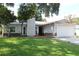 Charming single-story home with a metal roof, beautiful stonework, a well-kept lawn, and an attached two-car garage at 3821 Whitedove Dr, Lakeland, FL 33812