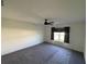 Light-filled bedroom with plush gray carpeting, a modern ceiling fan, and a window with dark curtains at 4516 Casablanca Ave, Kissimmee, FL 34746