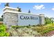 Casa Bella community sign in stone with beautiful landscaping and clear blue sky at 4516 Casablanca Ave, Kissimmee, FL 34746