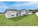 New construction home featuring a spacious backyard with healthy green lawn and modern design at 13276 Tula Loop, Astatula, FL 34705