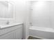 Bright bathroom with modern vanity, quartz countertop, and a tub with white tile surround at 13276 Tula Loop, Astatula, FL 34705