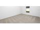 Minimalist bedroom with carpeted floors, a window overlooking the backyard, and white walls at 13276 Tula Loop, Astatula, FL 34705