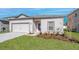 Inviting single-story home boasting a manicured lawn, two car garage, and traditional exterior at 13276 Tula Loop, Astatula, FL 34705
