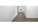 Long hallway featuring hardwood floors, neutral paint, and access to various rooms in the home at 13276 Tula Loop, Astatula, FL 34705