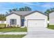 Charming single-story home featuring a well-manicured lawn and a two-car garage at 13438 Leaping Water Way, Astatula, FL 34705