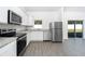 Well-lit kitchen with stainless steel appliances, white cabinets, and a view of the backyard at 13438 Leaping Water Way, Astatula, FL 34705