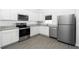 Modern kitchen featuring stainless steel appliances, white cabinets, and granite countertops at 13438 Leaping Water Way, Astatula, FL 34705